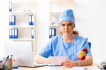 Young female doctor cardiologist sitting at the hospital 