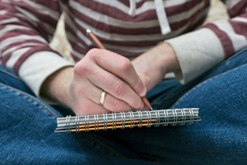 Closeup male writing in notebook. Concept in education and knowledge