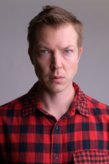 Obraz premium Face of young handsome hipster man against white background