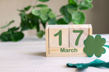 St.Patrick Day concept celebration. Green four leaf clover  and  wooden calendar  with  date 17 March. Irish Festive background with copy space.