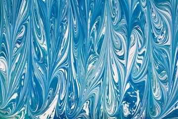 Fototapeta na wymiar Beautiful abstract drawing technique Ebru in blue .Turkish style of painting Ebru on water with acrylic paints swirls waves.A stylish combination of natural luxury 