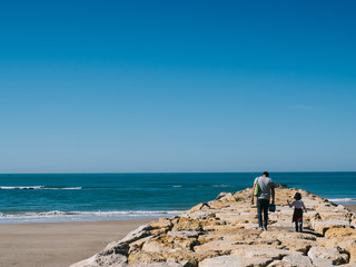 People walking along the shore of the beach
