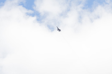 Military fighter in the blue sky with white clouds