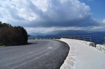 winding mountain road in verdon canyon cote azur in front of dramatic blue sky and clouds