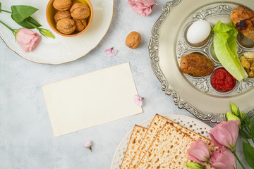 Jewish holiday Passover background with matzo, seder plate and spring flowers.