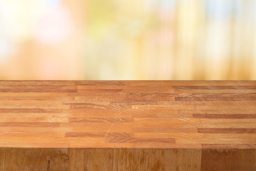 Empty wooden table over abstract bokeh background.