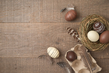 Fototapeta na wymiar Easter holiday background with brown easter eggs decorations on wooden table.