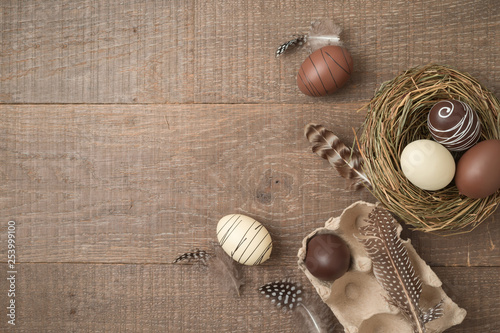 Easter holiday background with brown easter eggs decorations on wooden table.
