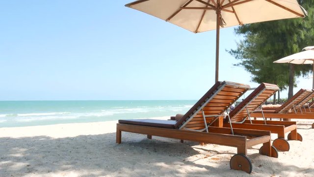 Peaceful travel scene, beach chairs under parasol on beautiful tropical island