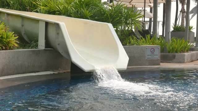 Closeup shot of a white water slide, with a small stream running down.