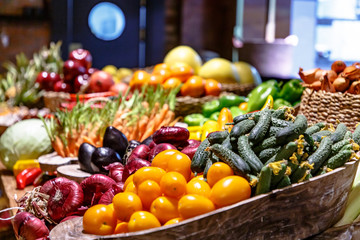 Vegetables (tomatoes, cucumbers, cabbage, carrots) are on the counter in the market.