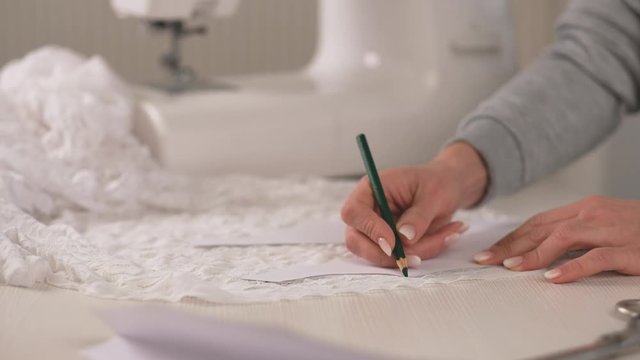 Proffesional seamstress making pettern with pencil