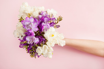 Girl hand holding bouquet flowers on background