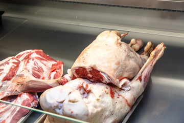 Pieces of lamb meat are on the counter in the market.