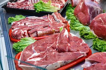 Pieces of lamb meat are on the counter in the market. © milanchikov