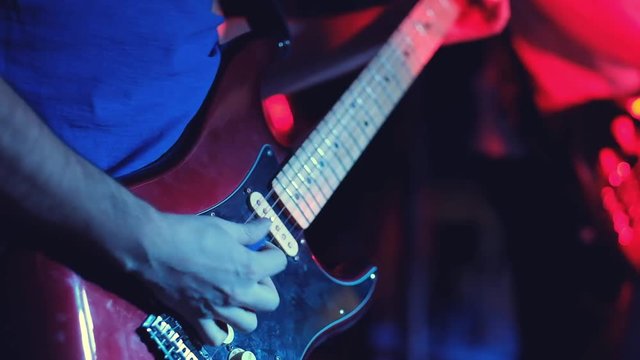 guitar player playing ona the guiter on the stage, close up