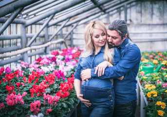Fototapeta premium Pregnant woman with her husband at greenhouse.