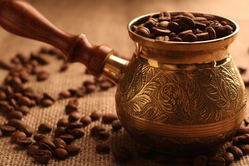 Turkish coffee pot and many coffee beans.