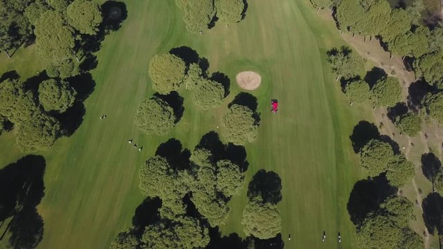 A tractor with loan mower working on a golf course