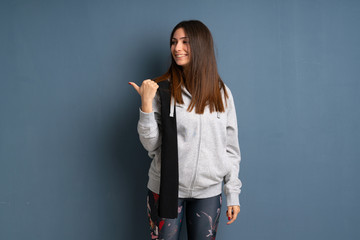 Young sport woman pointing to the side to present a product