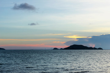 Naklejka na ściany i meble beautiful seascape, sunset behind island and above the sea at asia