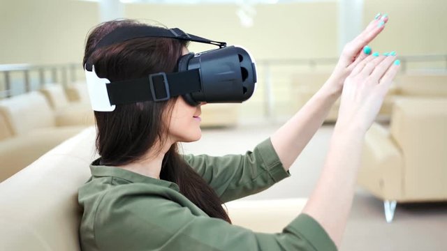 Side view concentrated happy woman enjoying using modern virtual reality glasses