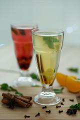 two glasses with colored hot drinks from which steam comes. winter hot seasonal vitemin drinks