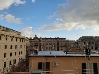Fototapeta na wymiar Genova, Italy - 03/05/2019: An amazing caption of the waterdro on the window with beautiful background of a blue sky and some white clouds.