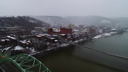 Aerial: Snowy Descent over Wheeling, West Virginia with Bridges.