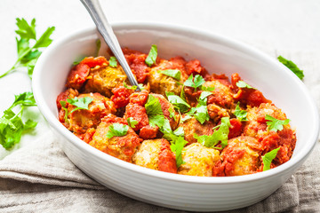 Baked vegan bean meatballs in tomato sauce.