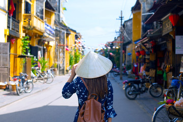 Woman tourist is travel into old town village in Hoi An, Vietnam.