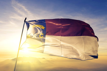 North Carolina state of United States flag waving on the top sunrise mist fog
