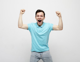 Fototapeta premium young man celebrating victory over white background