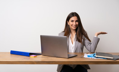 Business woman in a office holding copyspace imaginary on the palm to insert an ad