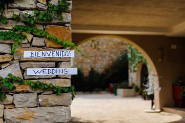Muro de piedra en zona rural con carteles con las palabras bienvenidos y Wedding
