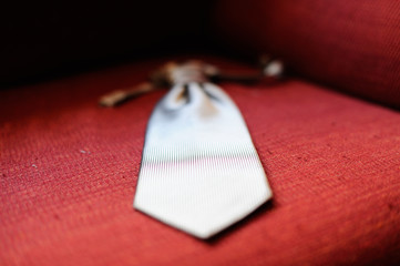 Corbata plateada con bokeh sobre tela roja