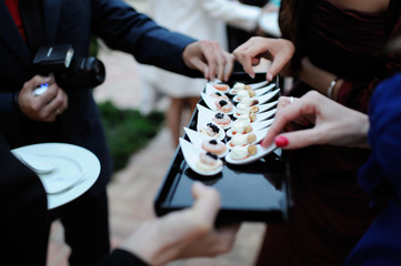 Manos de gente cogiendo comida de catering de diseño