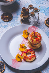 Few puff pastry donuts with strawberry topping on white plate