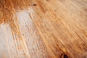 Obraz premium Close - up of a wet wooden surface with highlights on a rainy day.