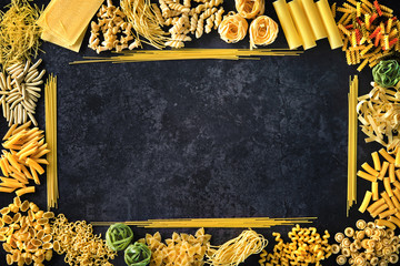 Various kinds of pasta over stone background.
