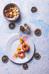Few puff pastry donuts with strawberry topping on white plate