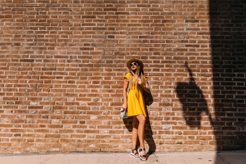 Fototapeta na wymiar stylish girl with long hair in a yellow dress and sunglasses nea
