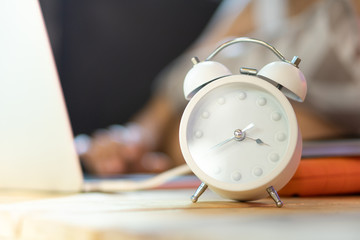 White alarm clock placed on the desk