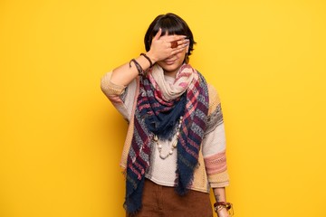Young hippie woman over yellow wall covering eyes by hands. Do not want to see something