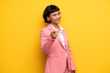 Modern woman with pink business suit points finger at you with a confident expression