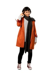 A full-length shot of a Short hair woman with coat making the gesture of madness putting finger on the head over isolated white background