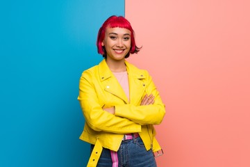 Young woman with yellow jacket keeping the arms crossed in frontal position