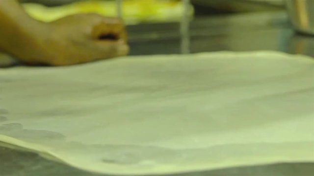 Closeup Of Indian Man Flipping Dough For Roti Canai At A Restaurant In Kuala Lumpur  