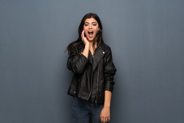 Teenager girl over grey wall with surprise and shocked facial expression
