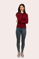 A full-length shot of a Teenager girl with turtleneck looking to the side over isolated background